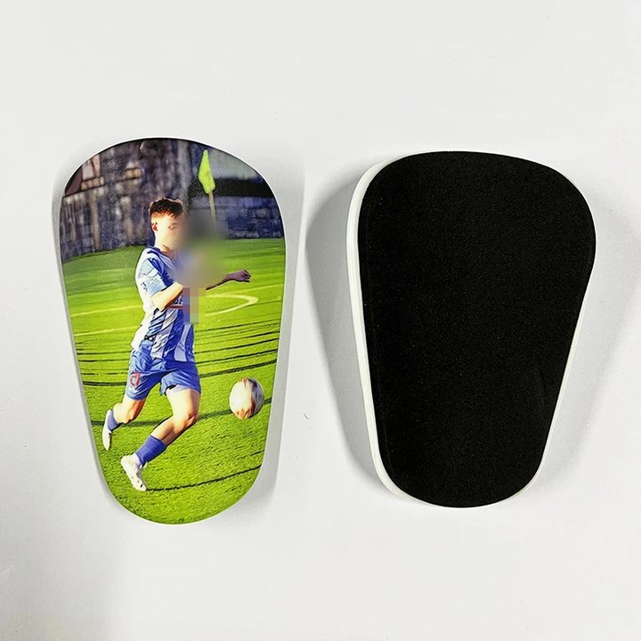 Mini shin guard printed with a player photo, beside its foam-lined back